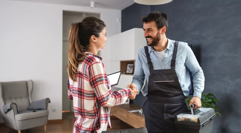 a homeowner happily shakes hands with a contractor