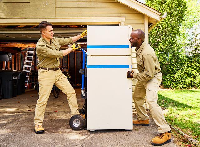 Two people moving a fridge
