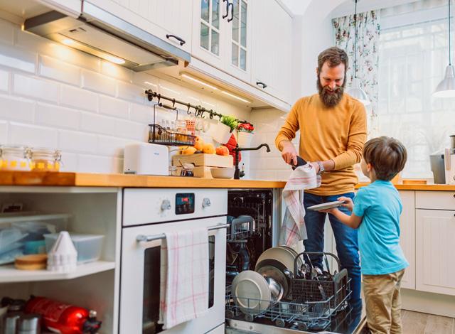 adult doing dishes with child